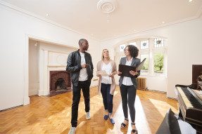 Real estate agent showing a home interior to clients