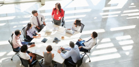 Group of Business People Sitting Around Table Having a Meeting