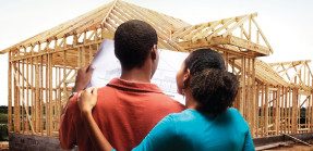 Couple looking at plans in front of timber frames