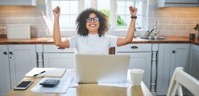 Businesswoman holding up her arms in celebration