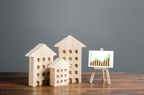 Toy wooden homes and easel holding bar graph