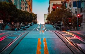 Twilight view of an empty road with cable car tracks leading up a steep hill on street at dawn, San Francisco, CA
