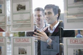 Two men looking at real estate listings