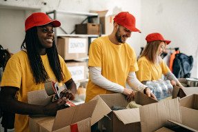 Volunteers in yellow shirts and red caps packing boxes