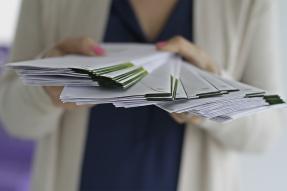 A woman holding a stack of envelopes