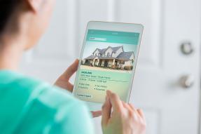 Woman looking at a home listing on a tablet