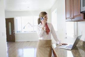 Woman on the phone in an empty house with the door open