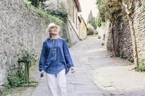 Woman walking down a cobblestone street in Italy