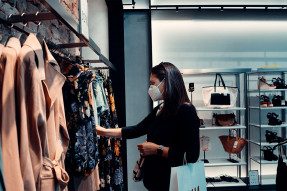 Woman wearing a mask shopping at a clothing store