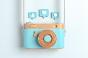 Wooden camera with Instagram icons above it
