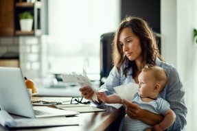 Young mother with baby going through bills