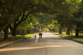 Young woman and dog jogging in a residential neighborhood