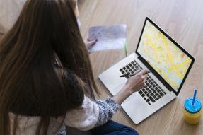 Young woman looking at a map on a laptop