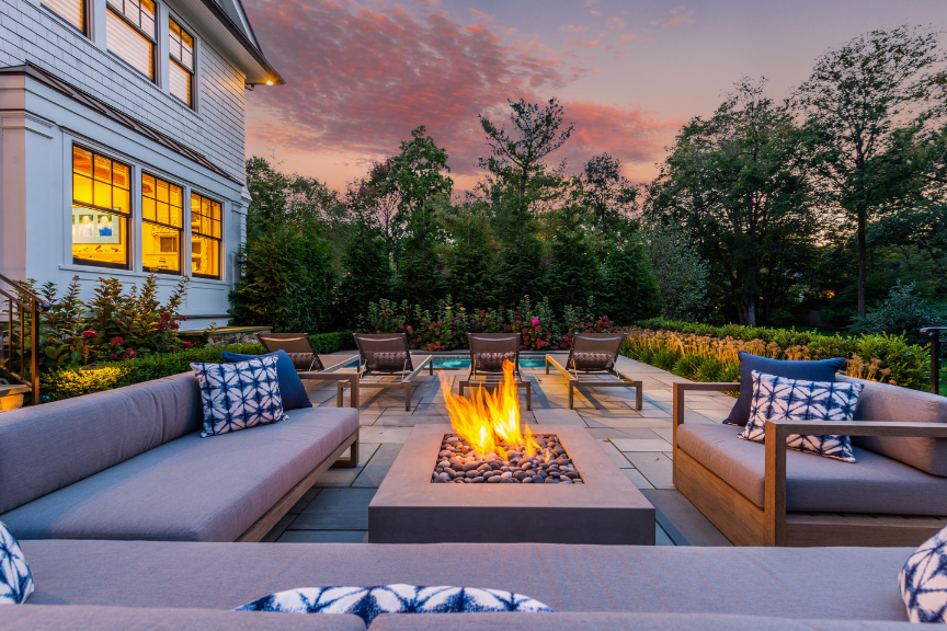 a lavish outdoor seating area with modern fire pit 