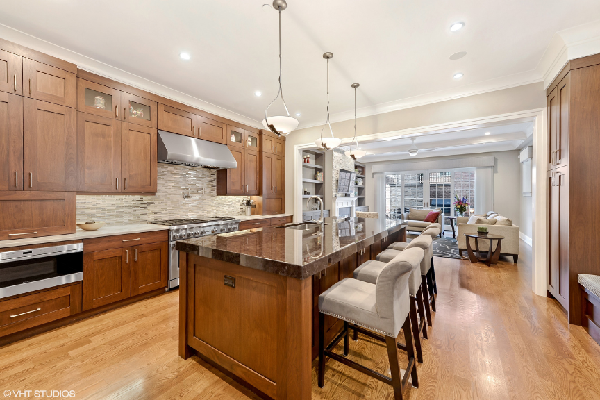 A large kitchen with hardwood floors, an island and medium wood cabinets