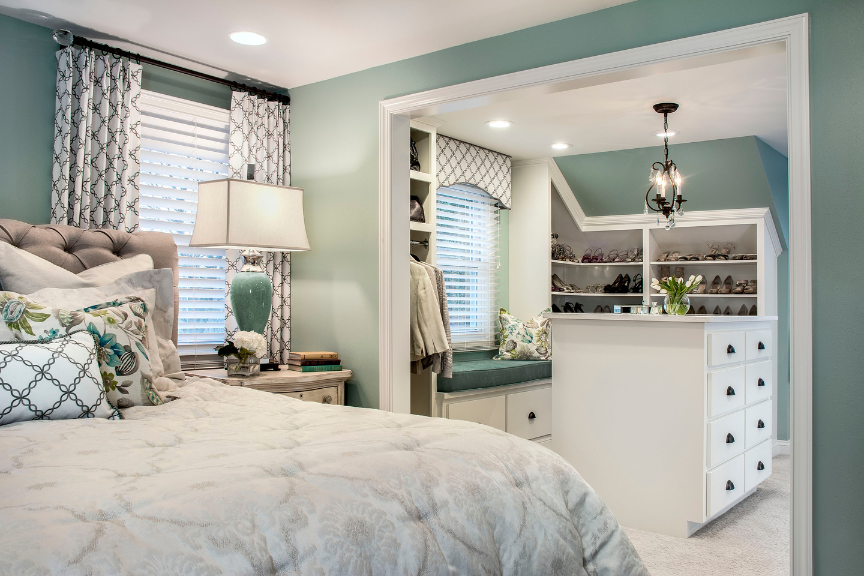 Bedroom decorated in gray and sea foam green with large walk-in closet that includes modern built-in storage