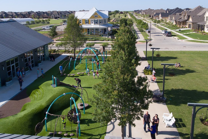 Aerial view of a multifamily complex with playground, field and community center