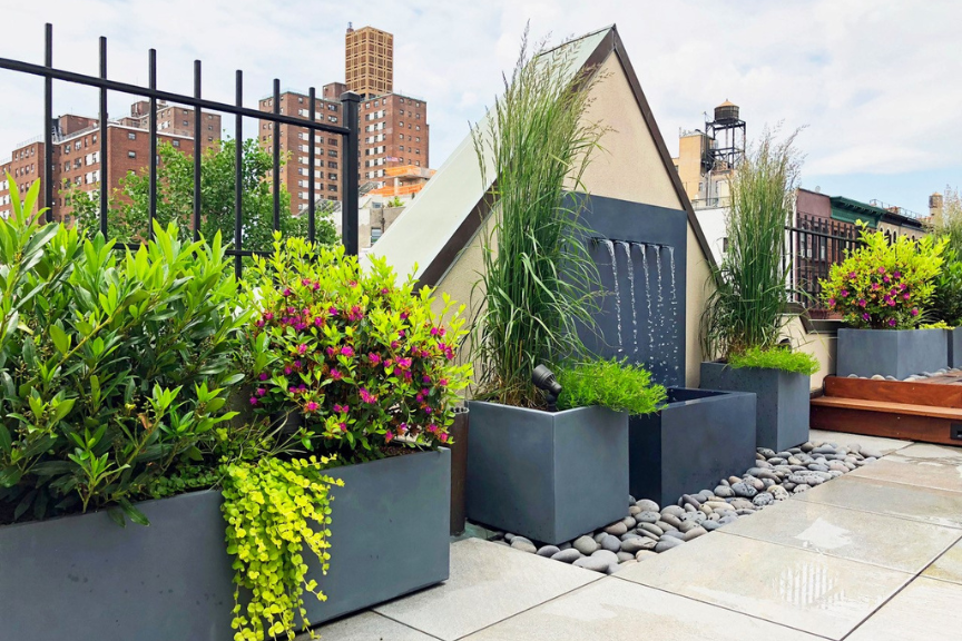 Outdoor landscape design with water feature and dark gray planters
