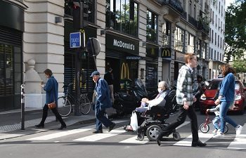 Person in wheechair crossing a busy street in Paris