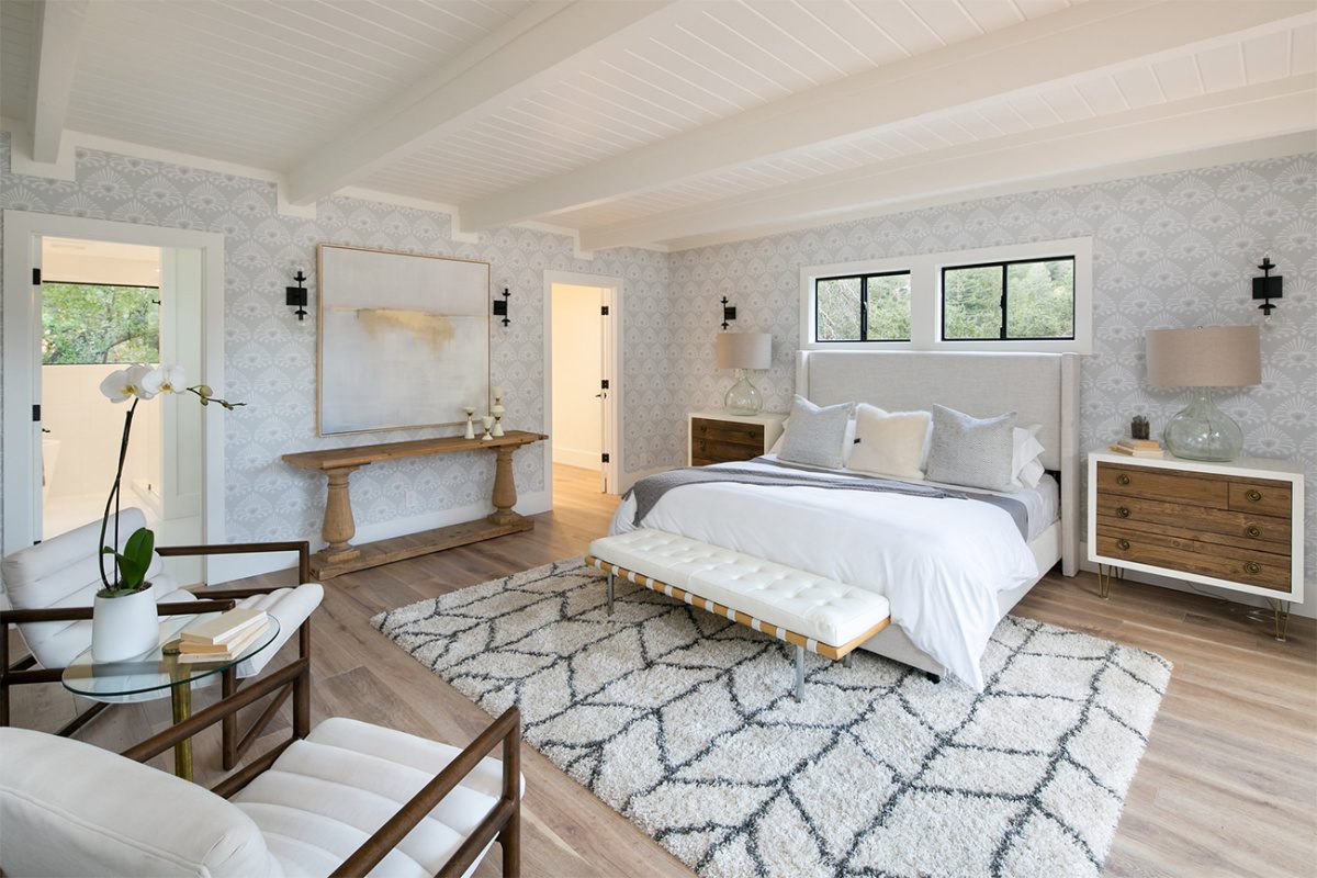 Bedroom with bed, throw rug, chairs, and ceiling beams