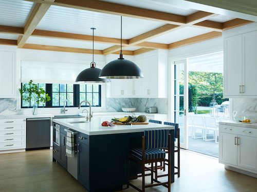 Large white kitchen with navy island and white countertops