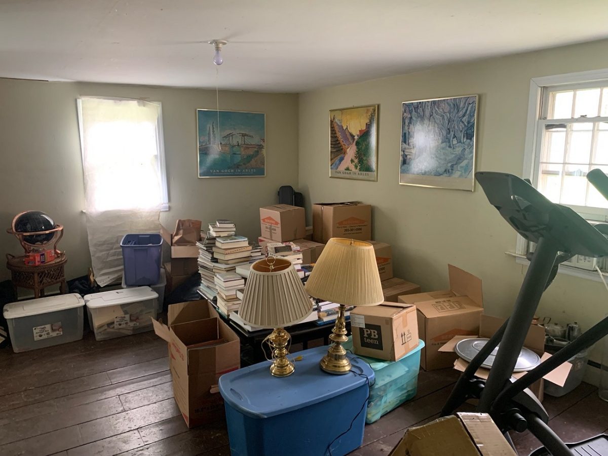 A room full of overflow storage - boxes, lamps, exercise equipment, etc. - before being redesigned and staged as a yoga room