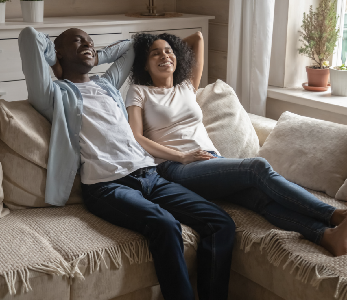Young couple relaxing on a couch in their home