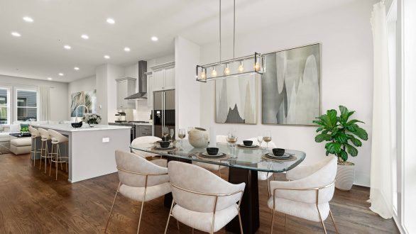 A dining room and kitchen staged with bright furniture and abstract art in gray tones