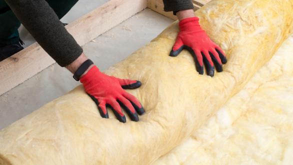 worker rolling out insulation