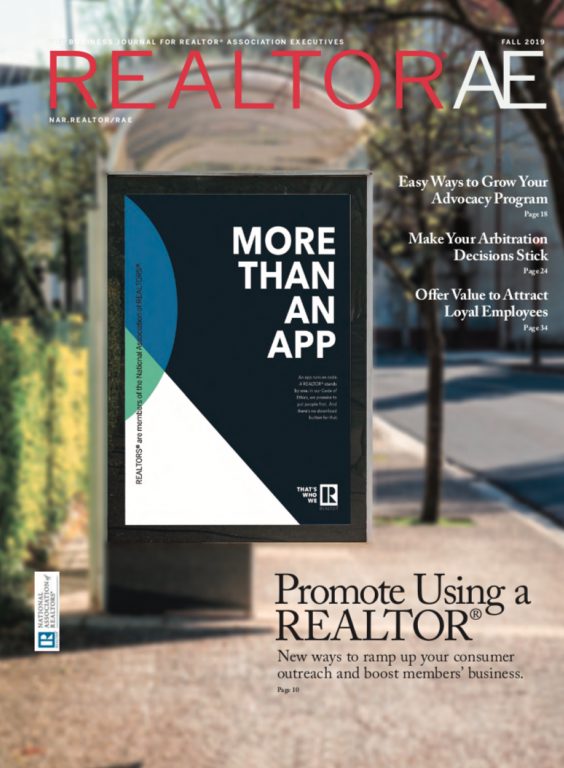 Cover of REALTOR® AE Fall Magazine with the slogo More Than An App on a billboard on a sidewalk