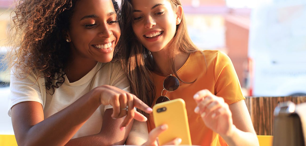 Two Women Smiling at Smartphone
