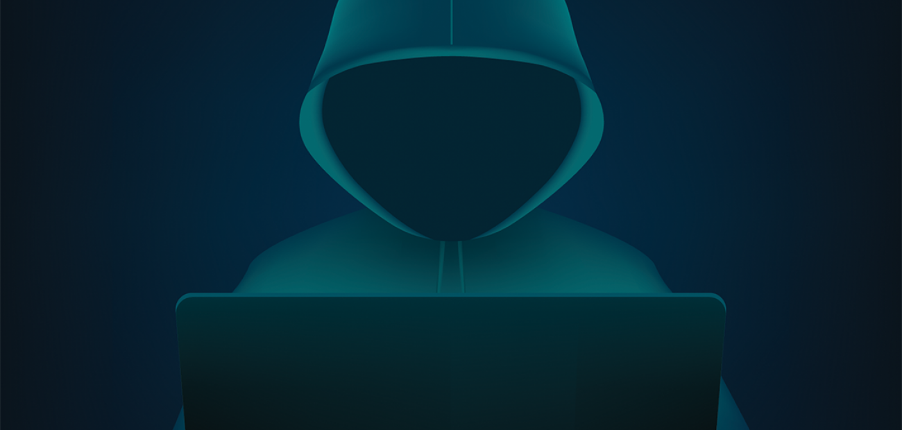 Image of hacker at computer in black and dark green image
