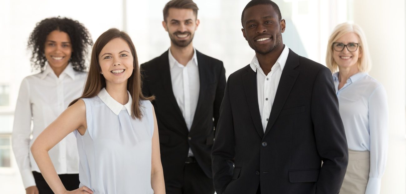 Group of people posing for portrait in business attire. 