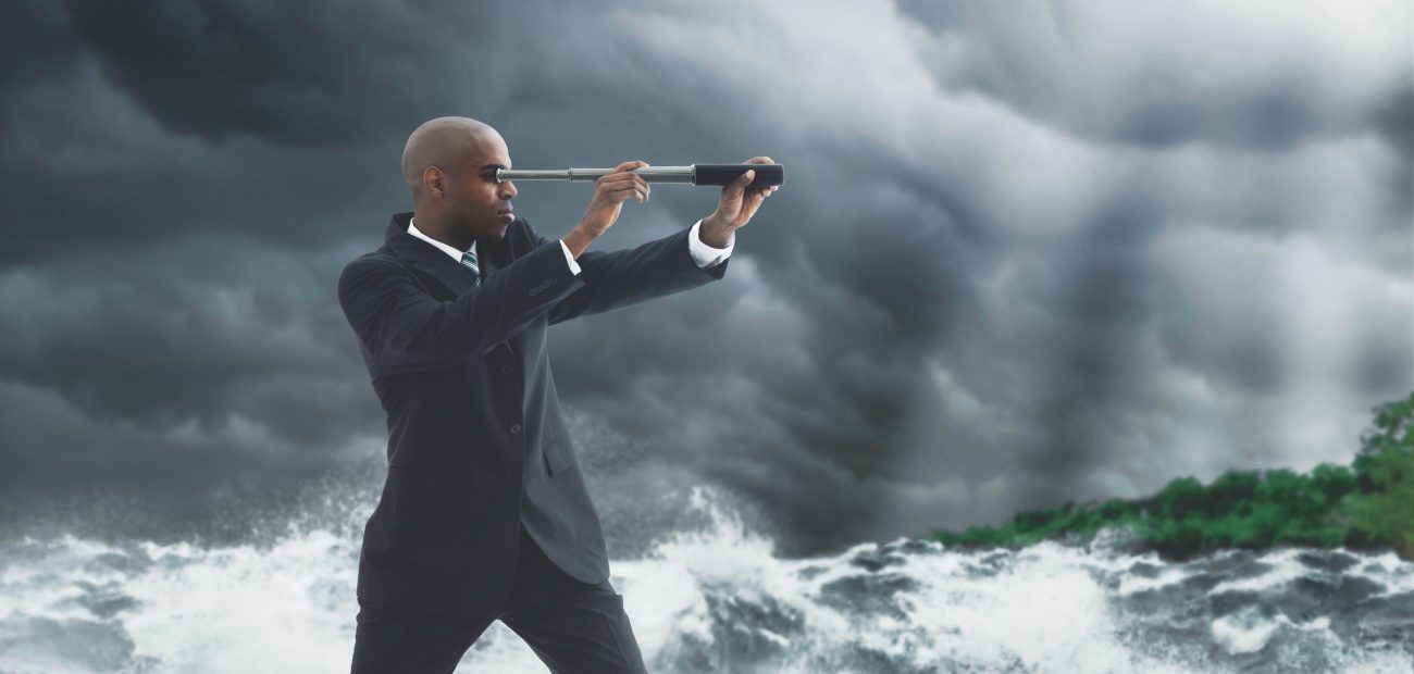 Businessman standing on a boat with a telescope in choppy waters at sea