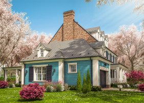 Blue and white house with cherry and azalea blossoms in the yard