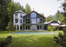 Dark gray house with white tower and back yard pool