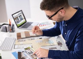 Real estate professional looking at floor plan of house