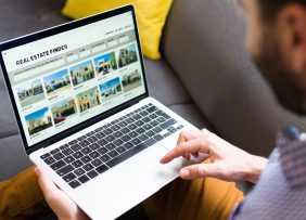 Person scanning real estate website on laptop