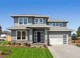 Gray two-story house with garage and landscaped yard