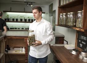Man behind the counter of a marijuana dispensary