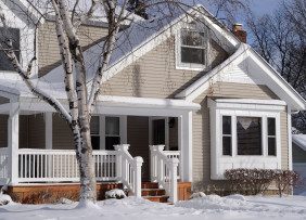 Two-Story Beige Midwestern Suburban House in Snow