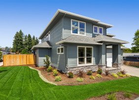 New small gray house with landscaping and lawn