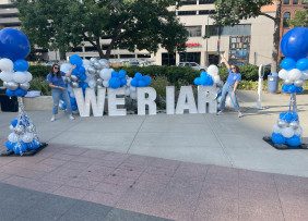 Iowa REALTORS® pose with "We R IAR" lettering during the Iowa REALTORS® Rock the Block Party in Des Moines, IA.