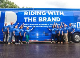 Missouri REALTORS® staff pose in front of the Riding with the Brand motor coach bus in Osage Beach, MO.