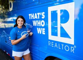 A Kansas REALTORS® member poses next to the Riding with the Brand motor coach bus.