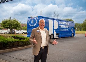 2023 NAR First Vice President Kevin Sears in front of the Riding with the Brand tour bus in Warwick, Rhode Island.