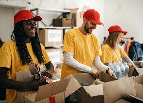 Volunteers in yellow shirts and red caps packing boxes