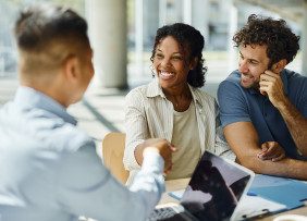 Young couple with agent in office