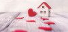 Toy house and red hearts on light defocused background
