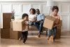 African american kids playing and holding boxes during moving day with parents smiling and watching them play